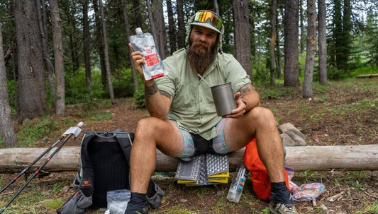 Backpacking holding up a non traditional backpacking food item called Recpak