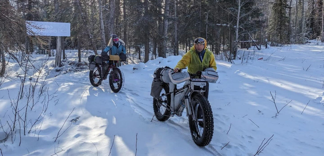 bicyclists hike on the Iditarod trail 