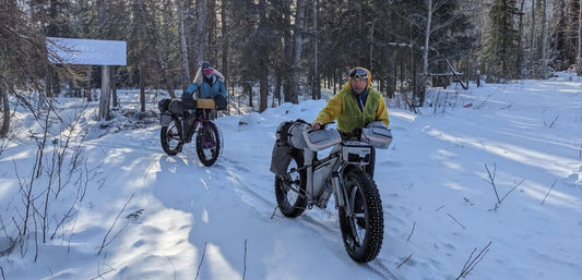 bicyclists hike on the Iditarod trail 