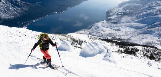 Woman skiing uphill in the backcountry while using best nutrition strategies for winter activities.