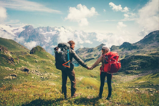 a backpacking couple holding hands after packing backpack with best backpacking packing tips